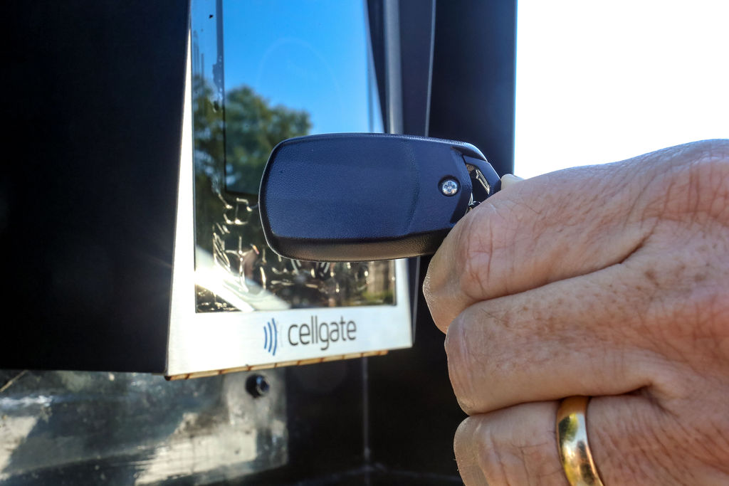 Close-up of a hand holding a key fob up to a Watchman W480 access control reader